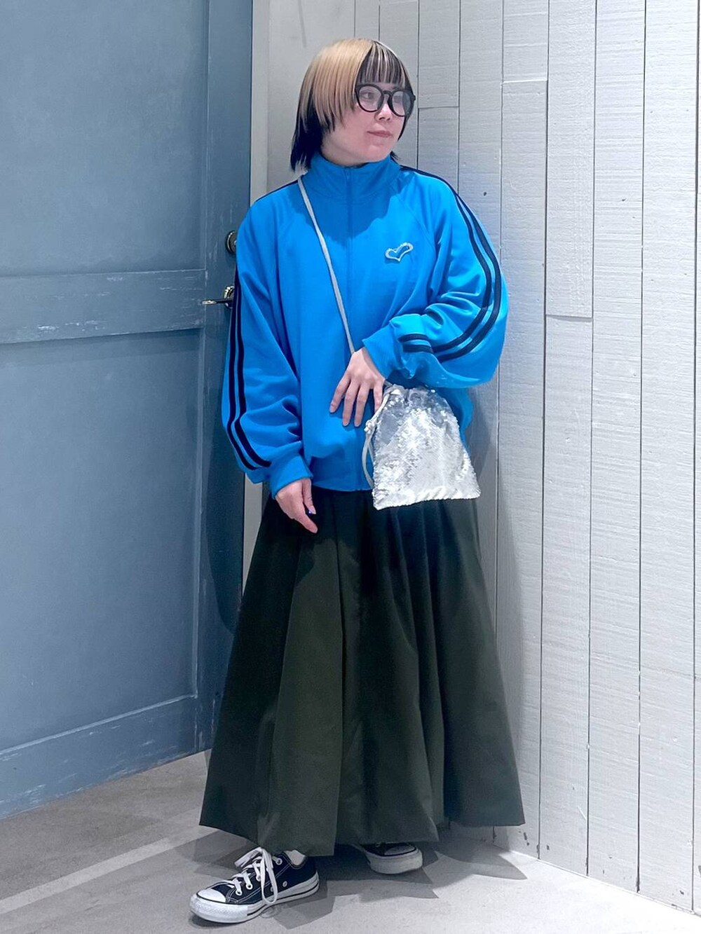 シルバー系のハンドバッグ、グリーン系のワンピース、ブルー系のTシャツ/カットソーを着用したレディースの秋コーディネートの2枚目の写真