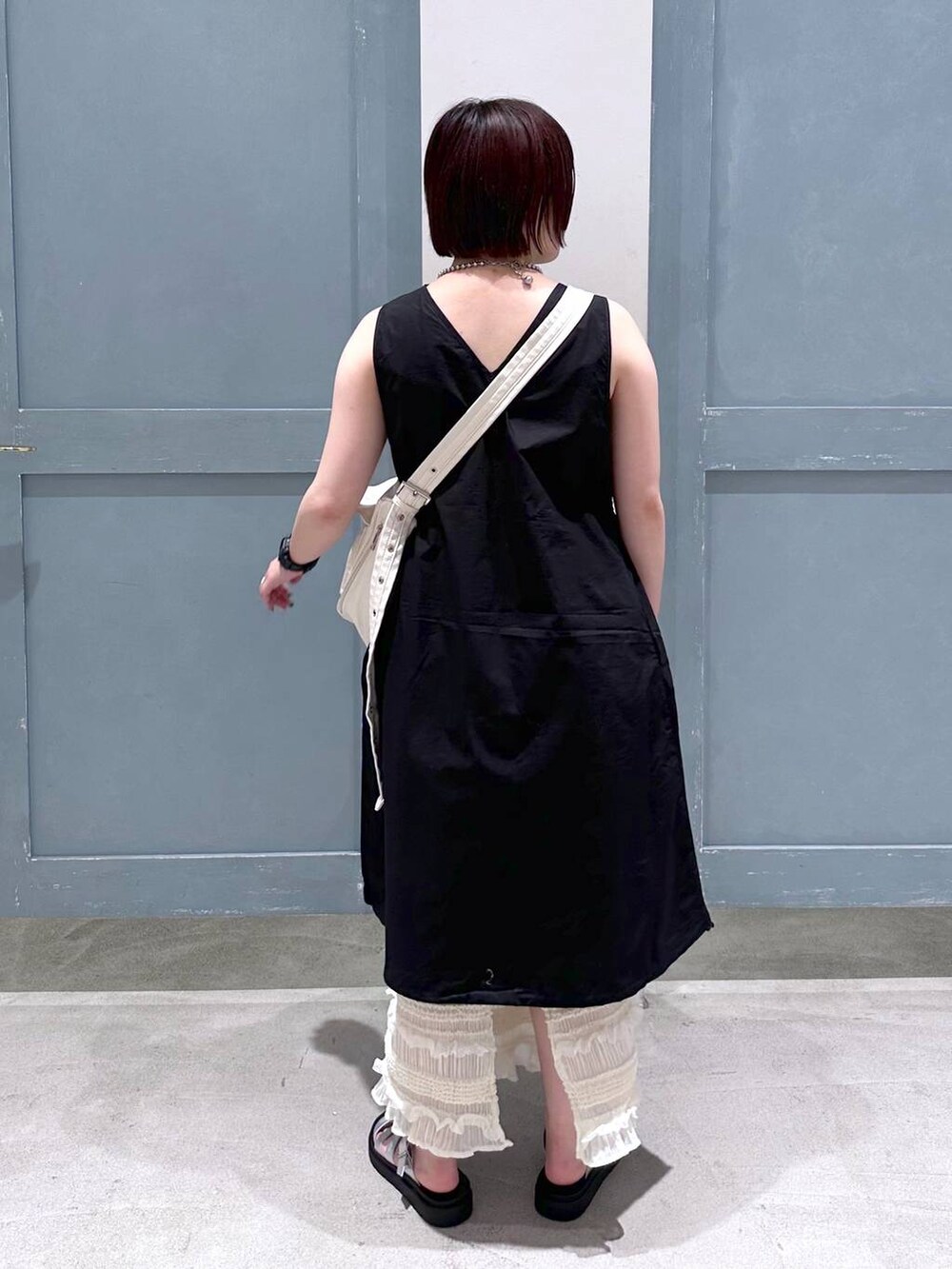 ブラック系のTシャツ/カットソー、ホワイト系のスカート、シルバー系のスニーカーを着用したレディースの夏コーディネートの4枚目の写真