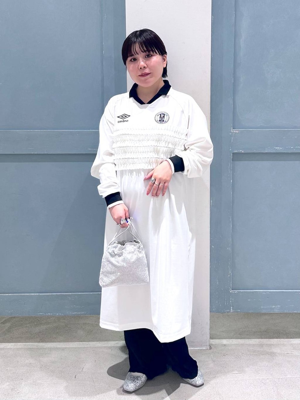 ブラック系のスラックス、シルバー系のショルダーバッグ、シルバー系のパンプスを着用したレディースの秋コーディネートの2枚目の写真