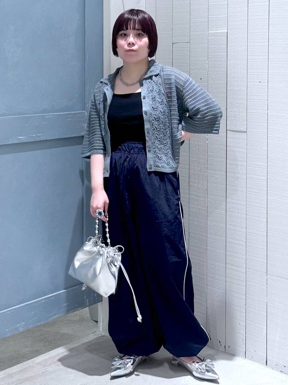 シルバー系のパンプス、ブラック系のタンクトップ、シルバー系のショルダーバッグを着用したレディースの夏コーディネートの2枚目の写真