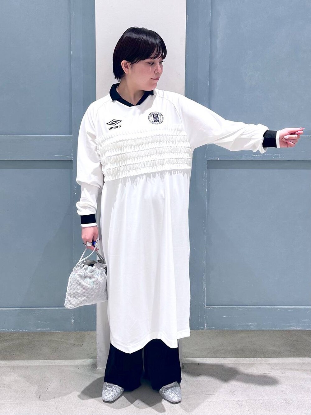 ブラック系のスラックス、シルバー系のショルダーバッグ、シルバー系のパンプスを着用したレディースの秋コーディネートの5枚目の写真