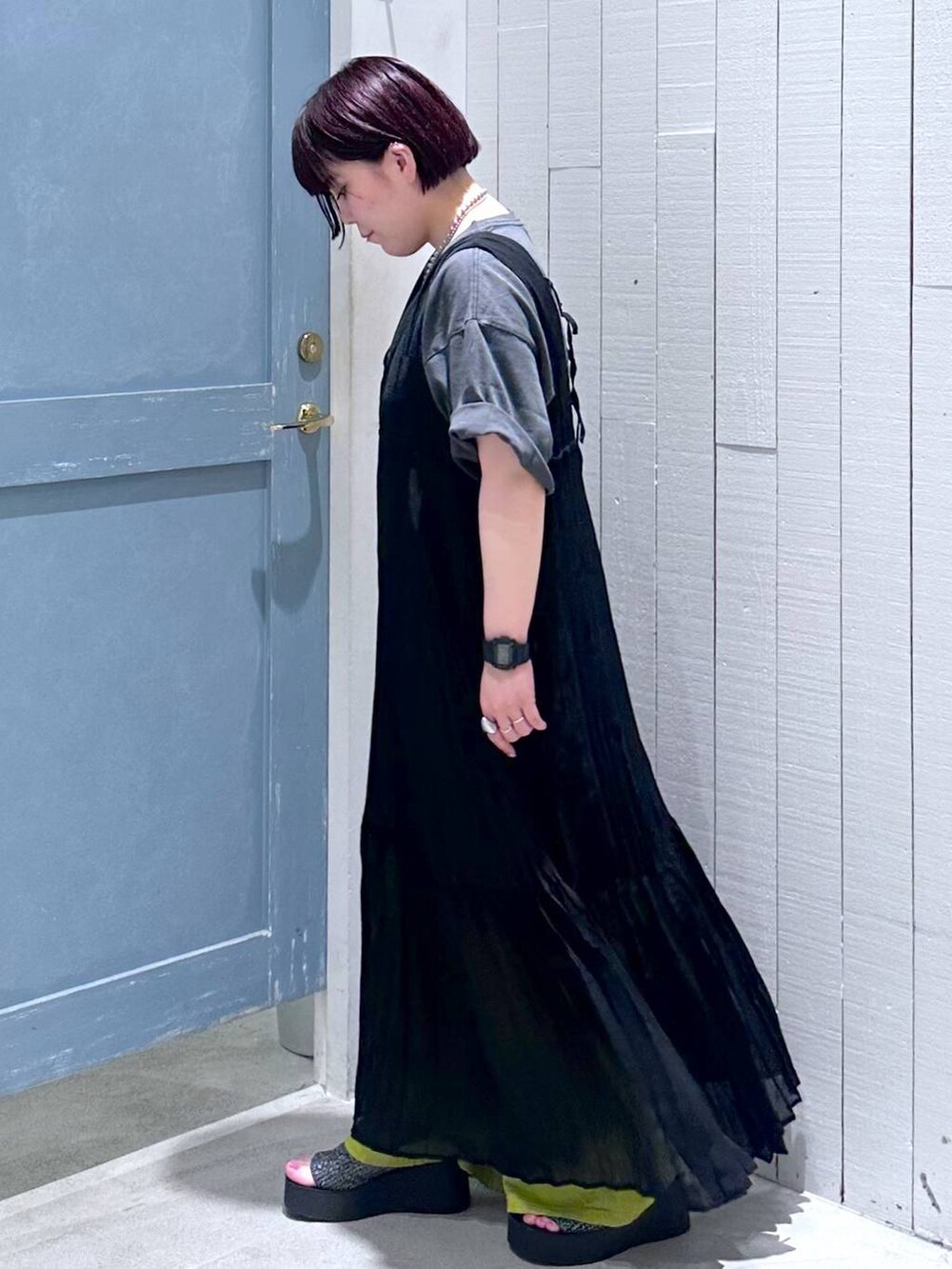 ブラック系のサンダル、ブラック系のショルダーバッグ、グリーン系のスラックスを着用したレディースの夏コーディネートの3枚目の写真