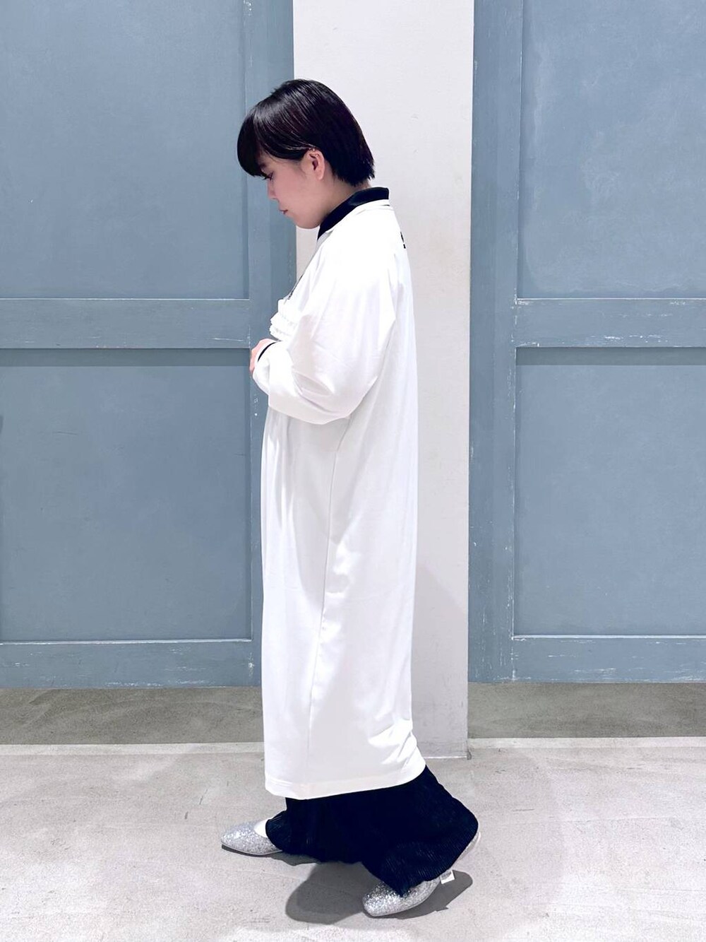 ブラック系のスラックス、シルバー系のショルダーバッグ、シルバー系のパンプスを着用したレディースの秋コーディネートの3枚目の写真