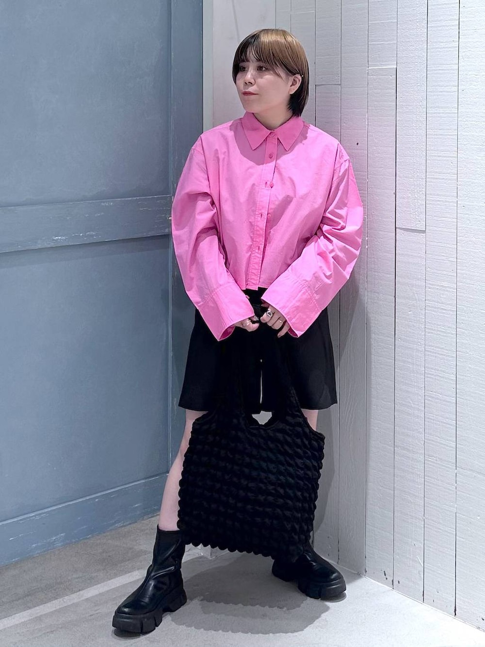 ブラック系のショルダーバッグ、ブラック系のブーツ、ピンク系のシャツ/ブラウスを着用したレディースの秋コーディネートの3枚目の写真