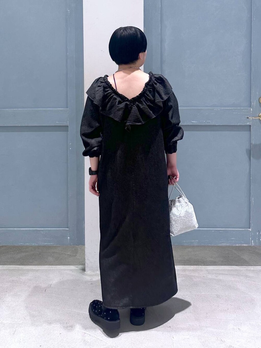 シルバー系のショルダーバッグ、その他のブーツ、ブラック系のワンピースを着用したレディースの秋コーディネートの5枚目の写真