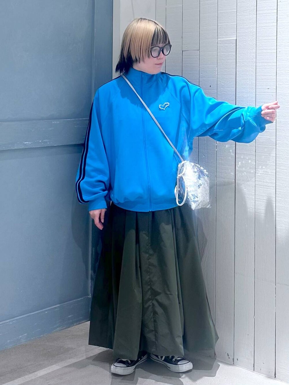 シルバー系のハンドバッグ、グリーン系のワンピース、ブルー系のTシャツ/カットソーを着用したレディースの秋コーディネートの6枚目の写真