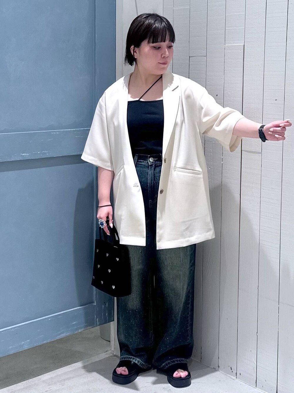 ブルー系のデニムパンツ、ブラック系のショルダーバッグ、ブラック系のサンダルを着用したレディースの夏コーディネートの5枚目の写真