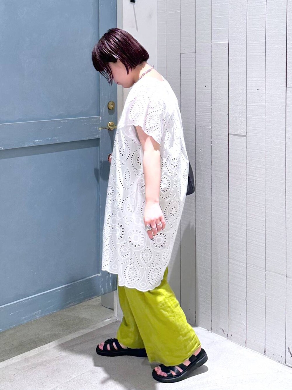 ホワイト系のワンピース、ブラック系のスニーカー、グリーン系のスラックスを着用したレディースの夏コーディネートの3枚目の写真