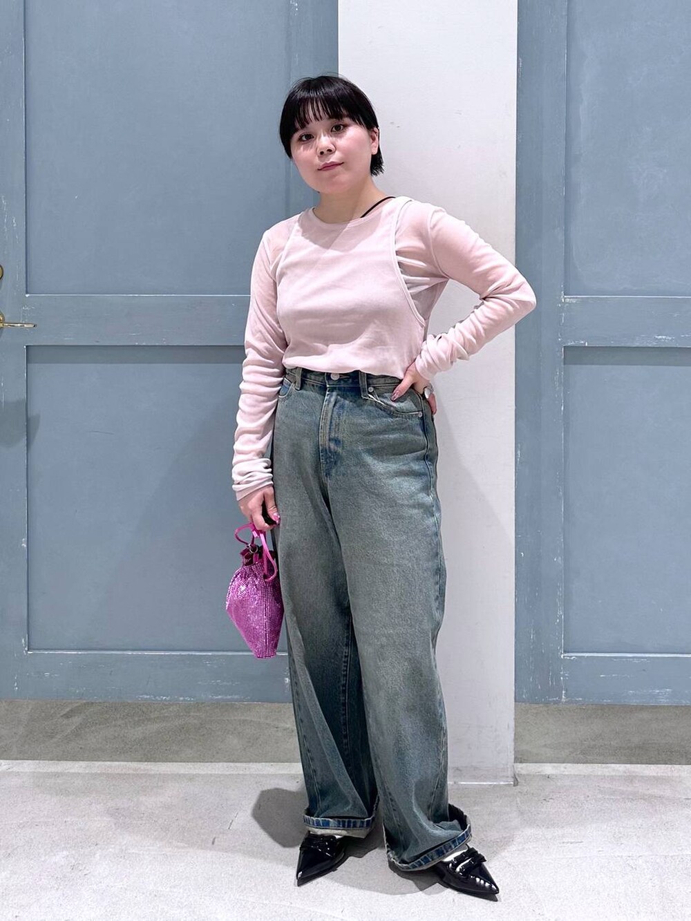 ブルー系のデニムパンツ、ブラック系のパンプス、ピンク系のショルダーバッグを着用したレディースの夏コーディネートの2枚目の写真