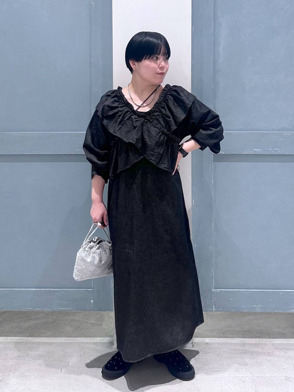 シルバー系のショルダーバッグ、その他のブーツ、ブラック系のワンピースを着用したレディースの秋コーディネートの2枚目の写真