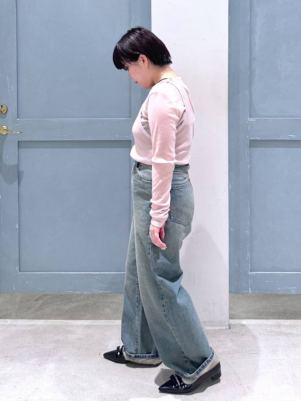 ブルー系のデニムパンツ、ブラック系のパンプス、ピンク系のショルダーバッグを着用したレディースの夏コーディネートの3枚目の写真