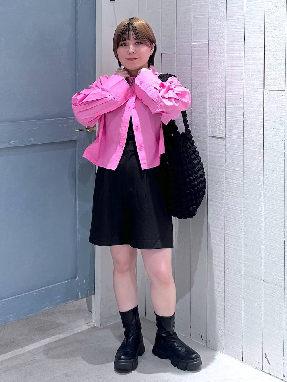 ブラック系のショルダーバッグ、ブラック系のブーツ、ピンク系のシャツ/ブラウスを着用したレディースの秋コーディネートの2枚目の写真