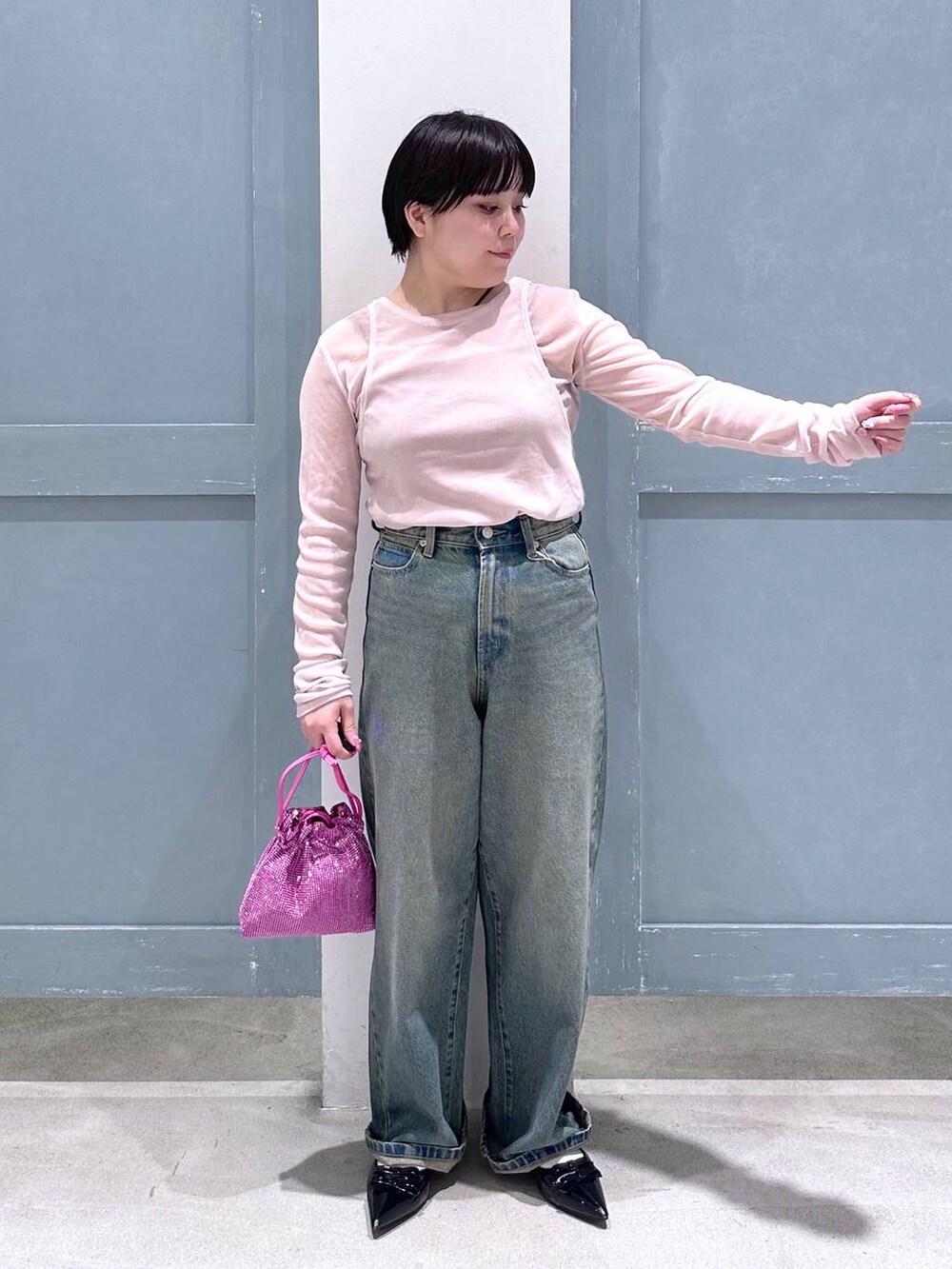 ブルー系のデニムパンツ、ブラック系のパンプス、ピンク系のショルダーバッグを着用したレディースの夏コーディネートの5枚目の写真