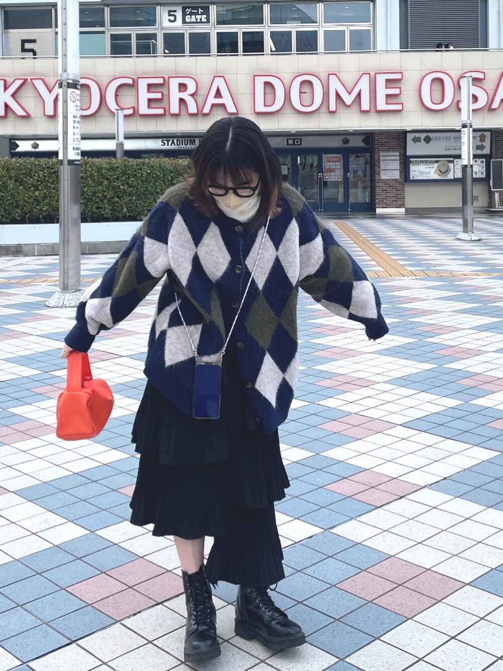 その他のカーディガン/ボレロ、オレンジ系のハンドバッグ、ブラック系のスカートを着用したレディースの春コーディネートの2枚目の写真