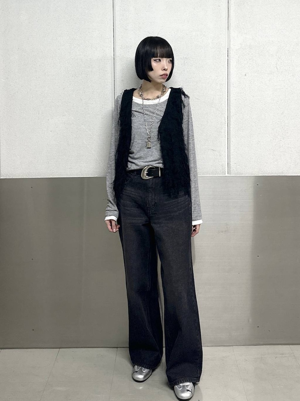 ブラック系のスラックス、ブラック系のベスト、グレー系のTシャツ/カットソーを着用したレディースの春コーディネートの2枚目の写真