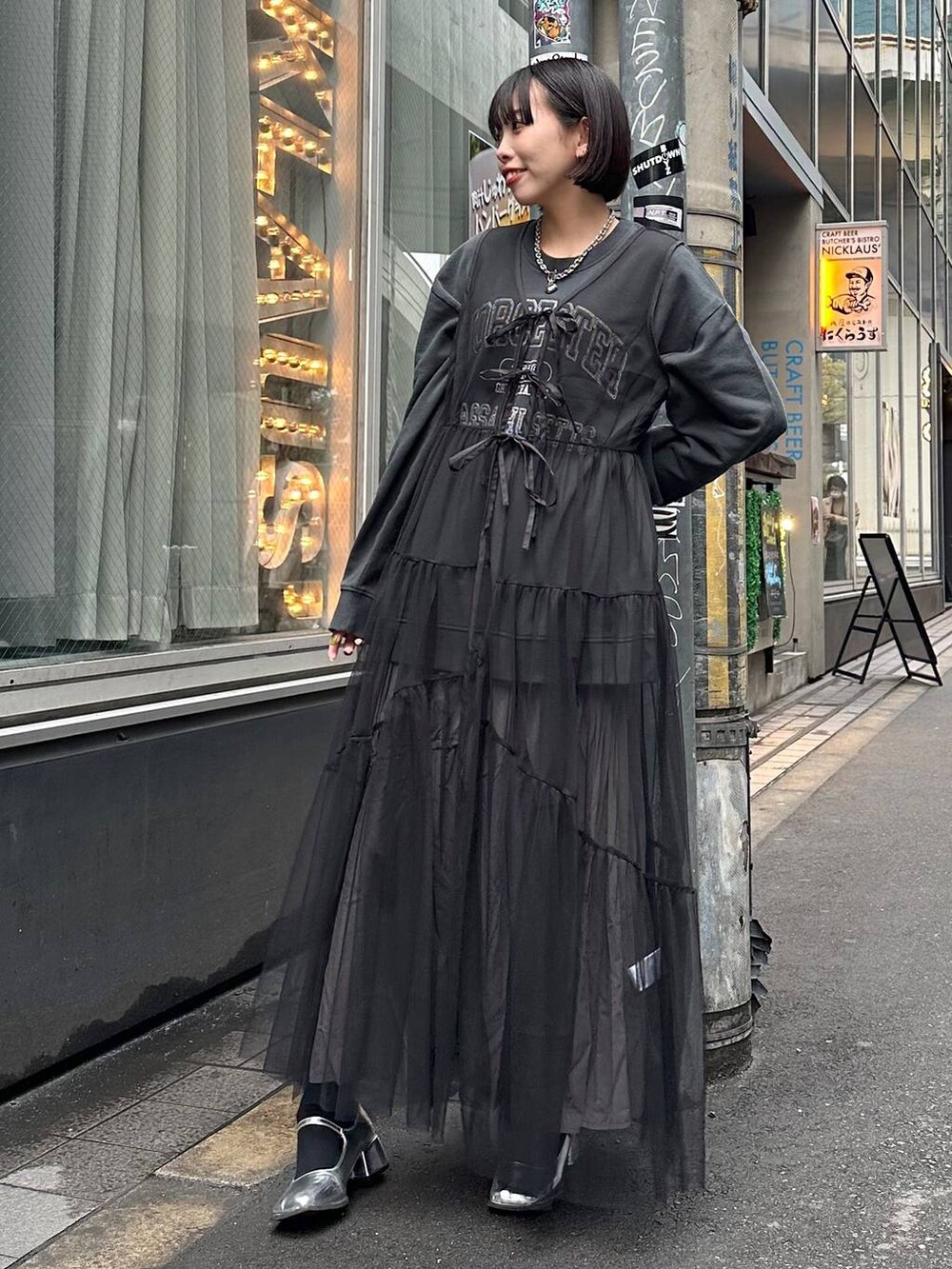 グレー系のスカート、ブラック系のワンピース、ブラック系のスウェットを着用したレディースの春コーディネートの4枚目の写真