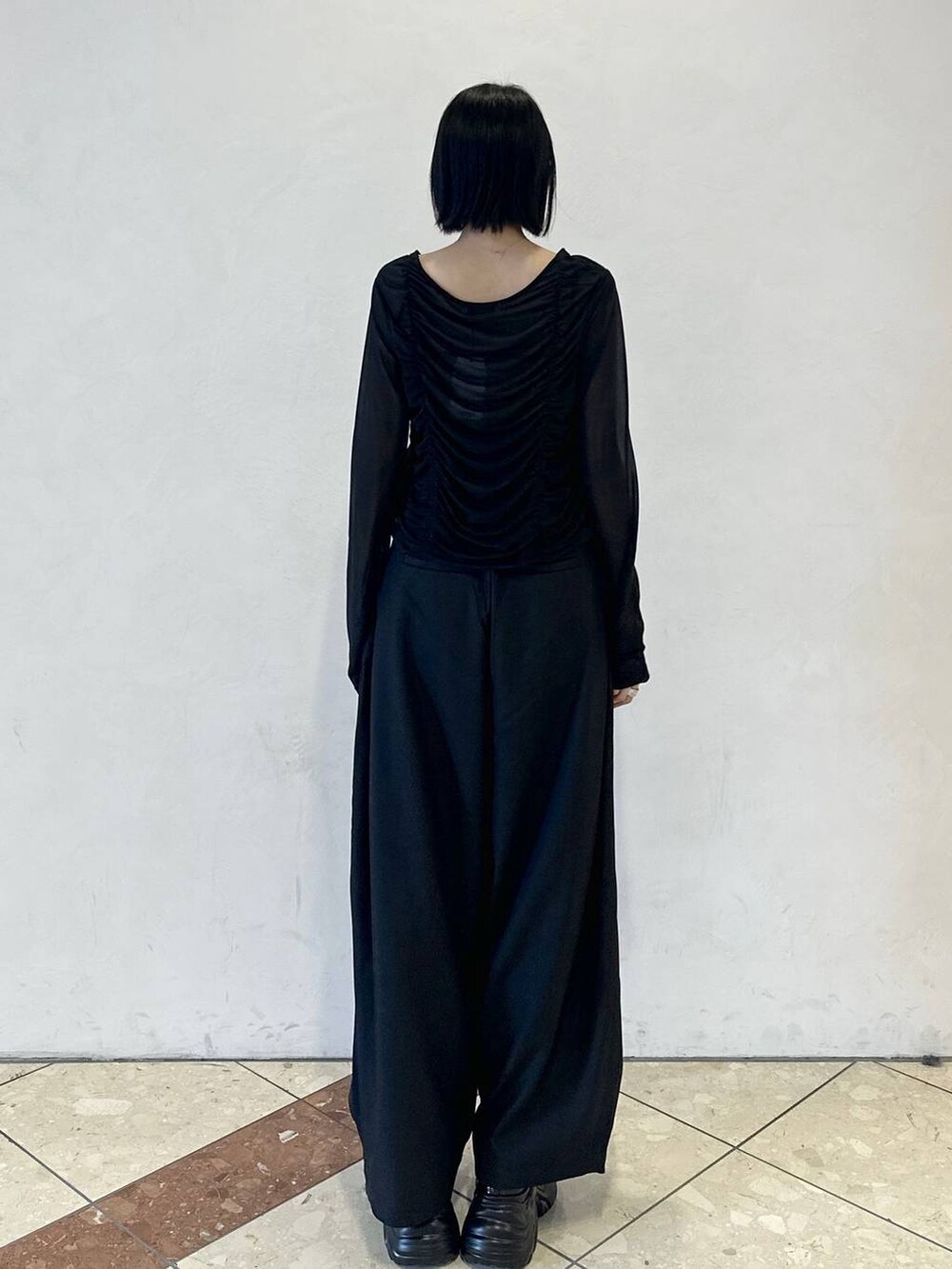 ブラック系のスニーカー、ブラック系のスラックス、ブラック系のTシャツ/カットソーを着用したレディースの春コーディネートの4枚目の写真