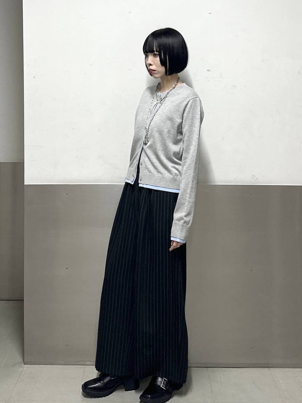 ブラック系のブーツ、ブラック系のスラックス、グレー系のカーディガン/ボレロを着用したレディースの冬コーディネートの3枚目の写真