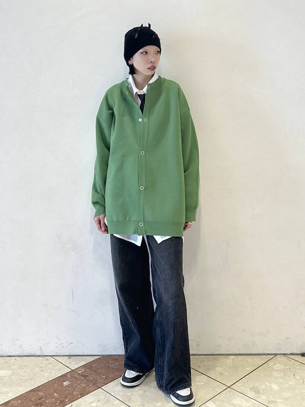 ブラック系のスラックス、ホワイト系のシャツ/ブラウス、グリーン系のカーディガン/ボレロを着用したレディースの春コーディネートの2枚目の写真