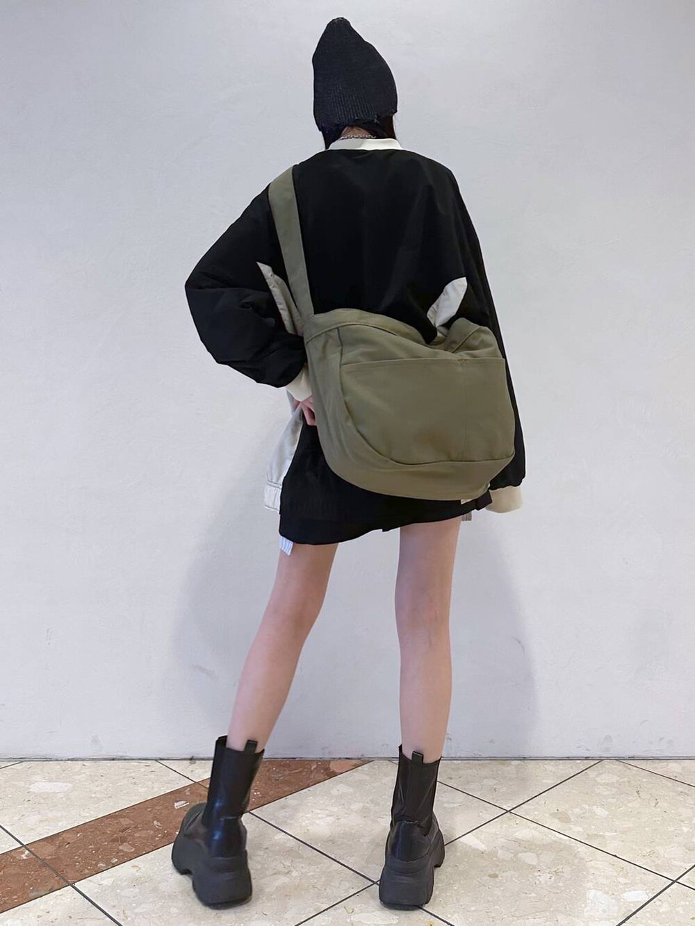 ブラック系のその他トップス、ブルー系のショルダーバッグ、ブラック系のブーツを着用したレディースの春コーディネートの4枚目の写真