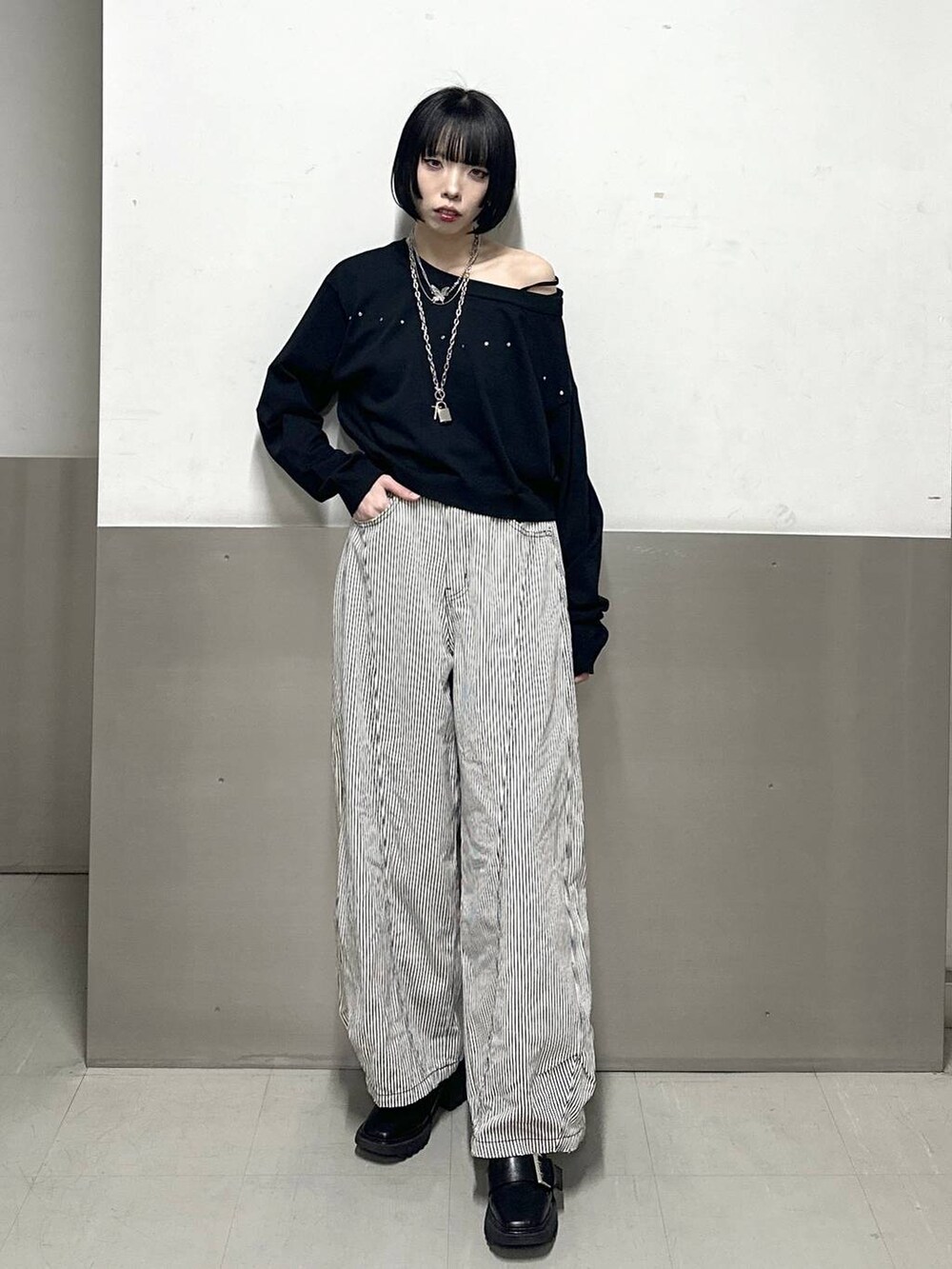 ブラック系のブーツ、ブラック系のニット/セーター、ブラック系のデニムパンツを着用したレディースの冬コーディネートの2枚目の写真