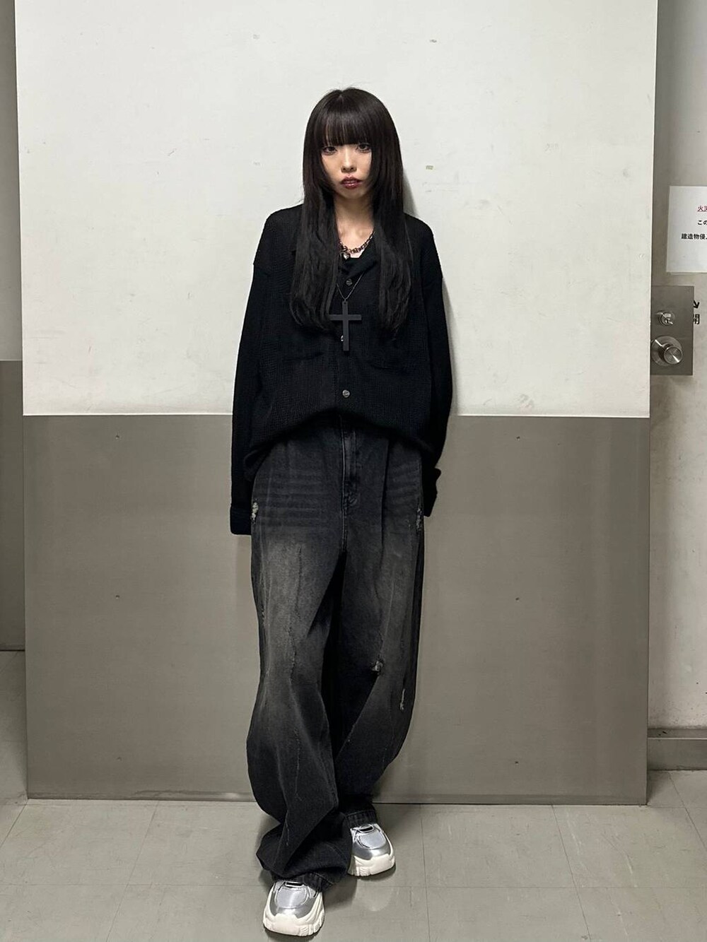 シルバー系のスニーカー、ブラック系のデニムパンツ、ブラック系のシャツ/ブラウスを着用したレディースの秋コーディネートの2枚目の写真