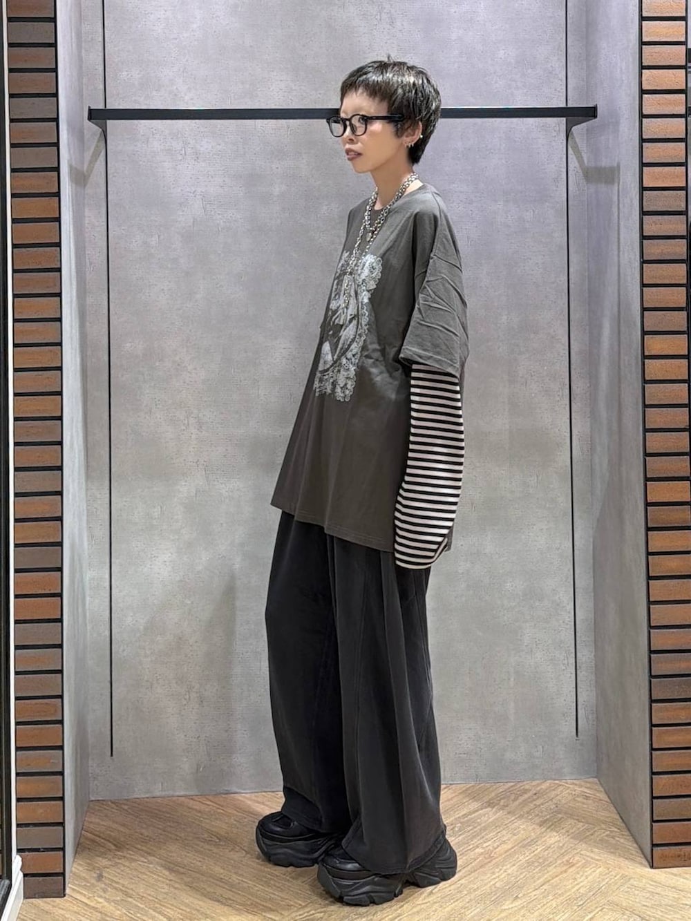 ブラック系のスウェットパンツ、ブラック系のスニーカー、グリーン系のTシャツ/カットソーを着用したレディースの夏コーディネートの3枚目の写真