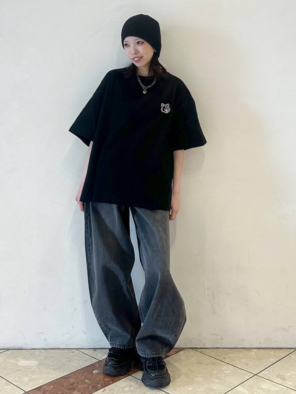 ブラック系のスニーカー、ブラック系のデニムパンツ、ブラック系のTシャツ/カットソーを着用したレディースの春コーディネートの2枚目の写真