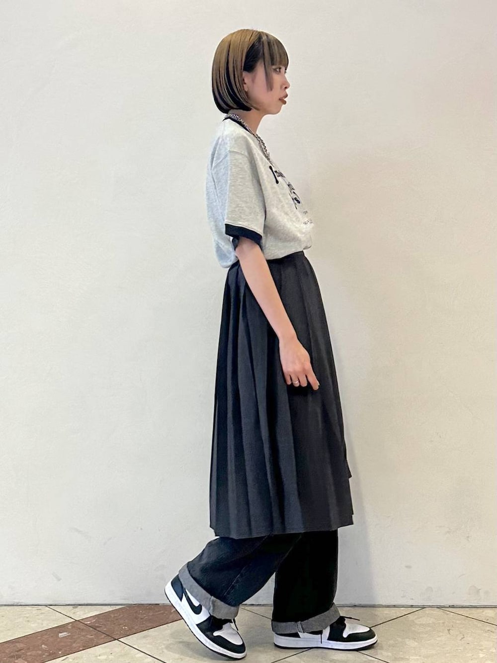 グレー系のスカート、ブラック系のデニムパンツ、グレー系のTシャツ/カットソーを着用したレディースの夏コーディネートの3枚目の写真