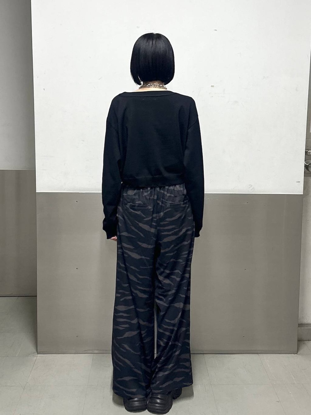 ブラック系のスニーカー、ブラック系のニット/セーター、その他のスラックスを着用したレディースの冬コーディネートの4枚目の写真