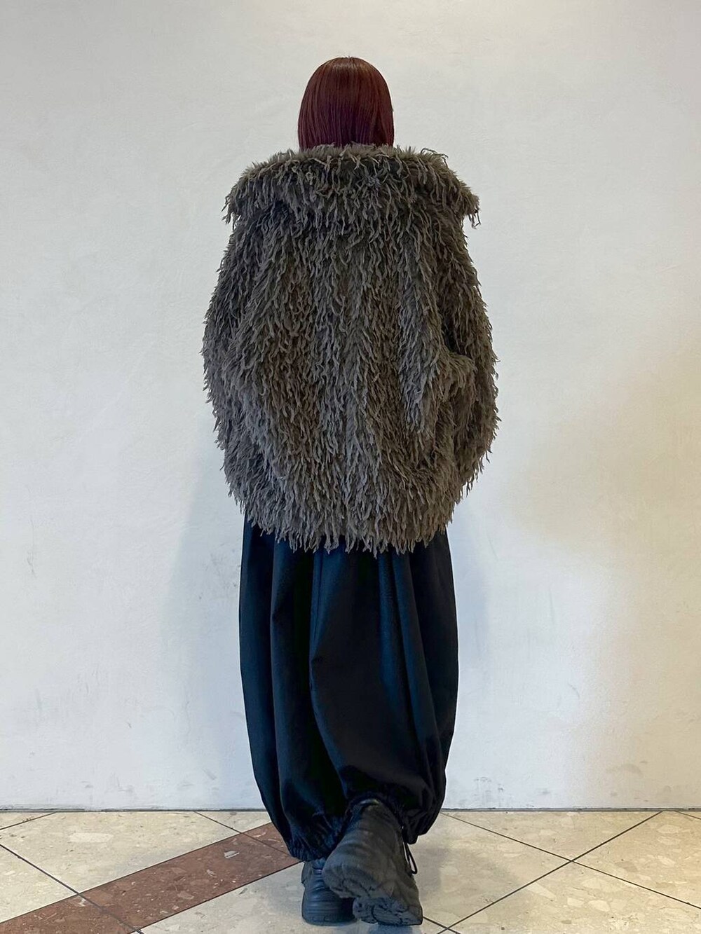 ブラック系のスニーカー、ブラック系のTシャツ/カットソー、ブラウン系のブルゾンを着用したレディースの秋コーディネートの4枚目の写真