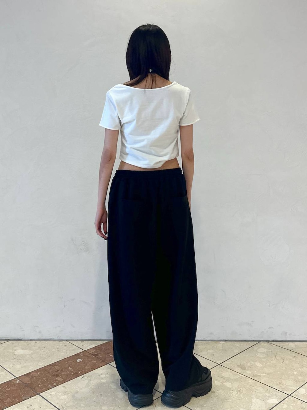 ブラック系のスニーカー、ホワイト系のTシャツ/カットソー、ブラック系のその他パンツを着用したレディースの夏コーディネートの4枚目の写真