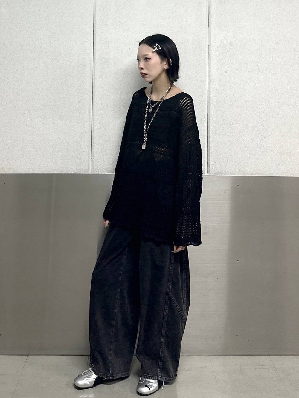 ブラック系のデニムパンツ、ブラック系のニット/セーター、ブラック系のネックレスを着用したレディースの春コーディネートの3枚目の写真