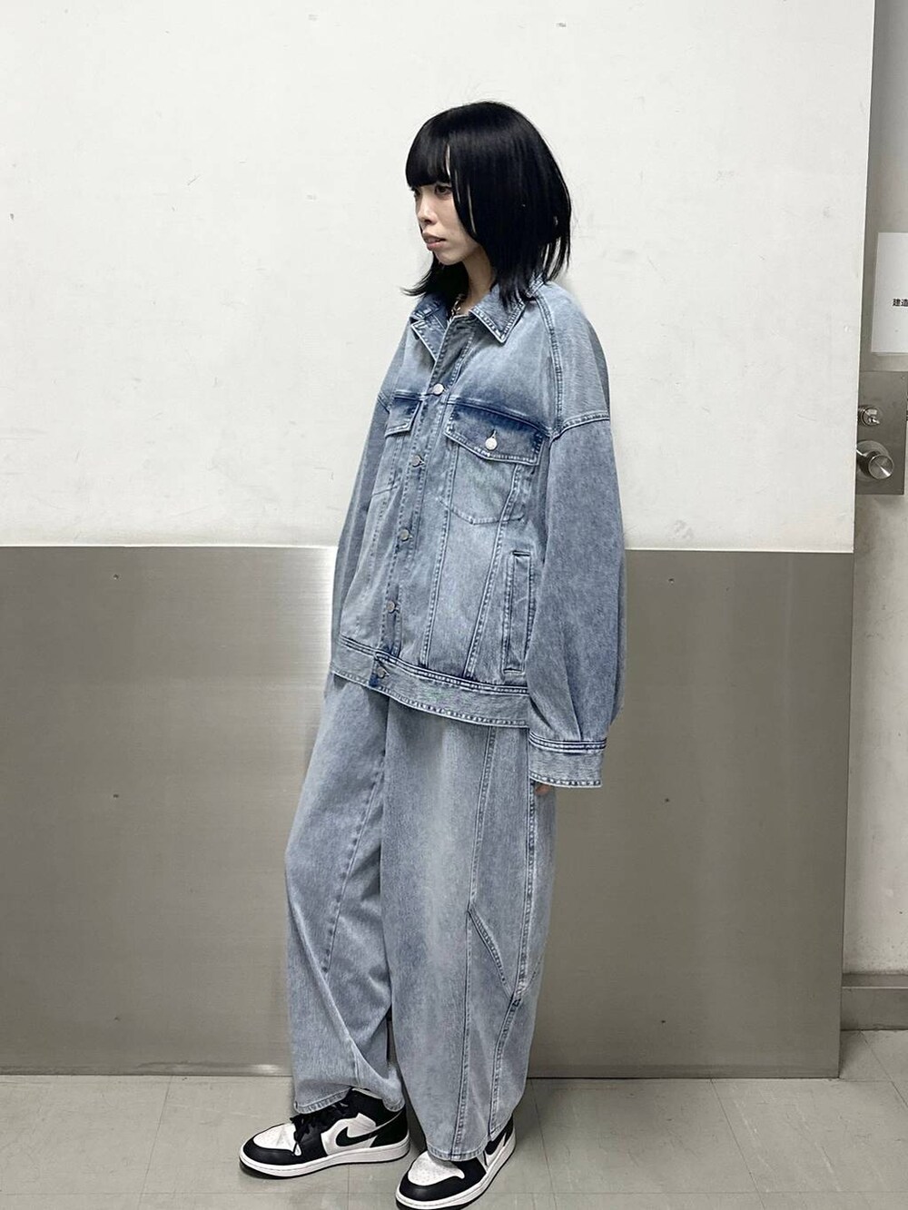 ブルー系のブルゾン、ホワイト系のニット/セーター、ブルー系のデニムパンツを着用したレディースの冬コーディネートの3枚目の写真