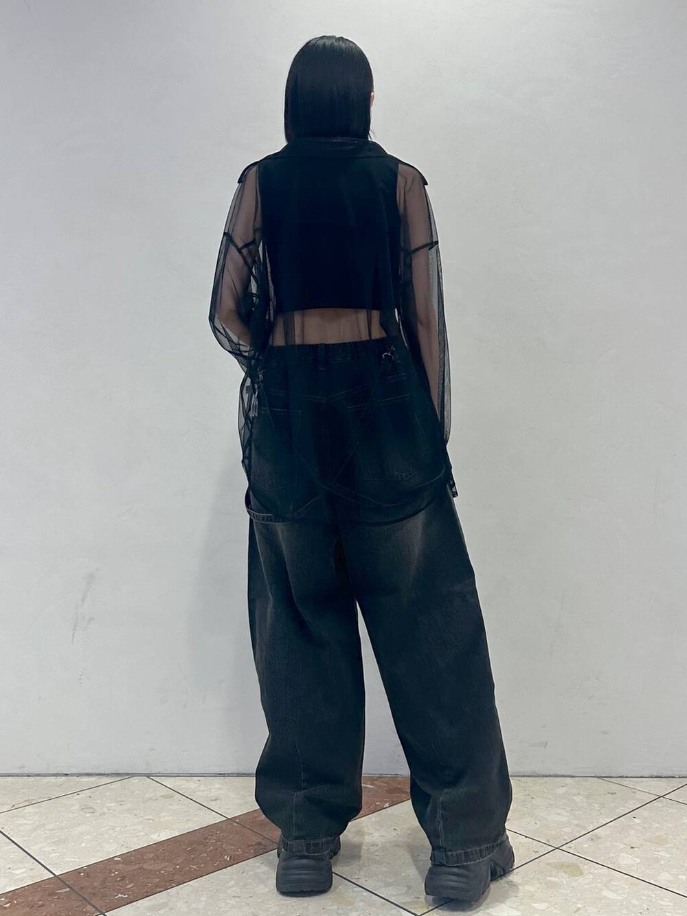 ブラック系のスニーカー、ブラック系のデニムパンツ、ブラック系のシャツ/ブラウスを着用したレディースの春コーディネートの4枚目の写真