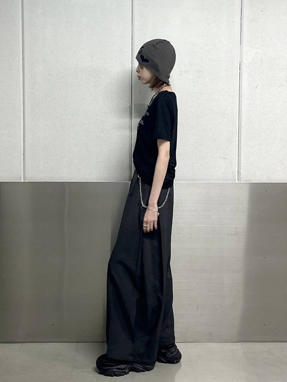 ブラック系のスニーカー、グレー系のスラックス、ブラック系のTシャツ/カットソーを着用したレディースの春コーディネートの3枚目の写真