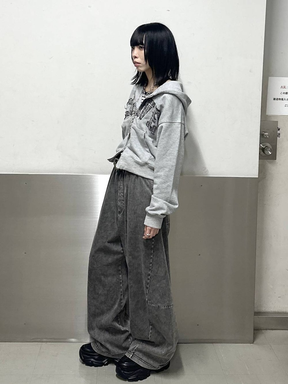 ブラック系のスニーカー、ホワイト系のニット/セーター、グレー系のパーカーを着用したレディースの冬コーディネートの3枚目の写真