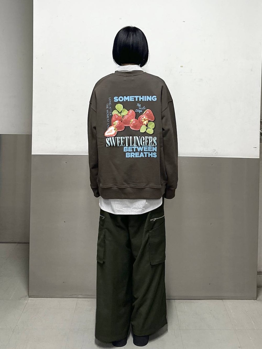 ブラック系のブーツ、グリーン系のスラックス、ブラウン系のスウェットを着用したレディースの冬コーディネートの4枚目の写真