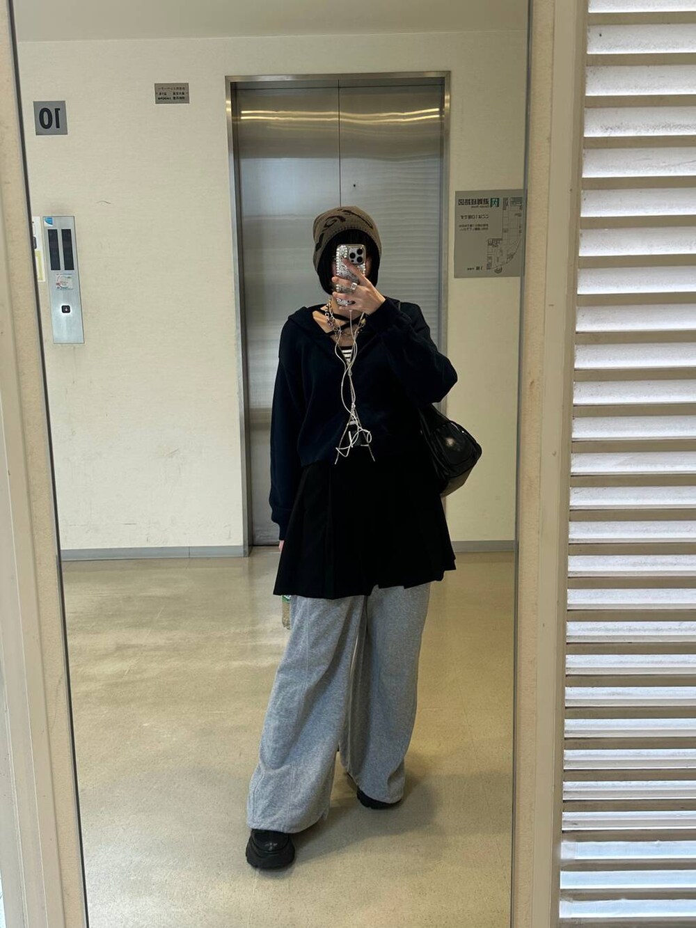 ブラック系のスニーカー、ブラック系のその他パンツ、ホワイト系のニット/セーターを着用したレディースの冬コーディネートの2枚目の写真