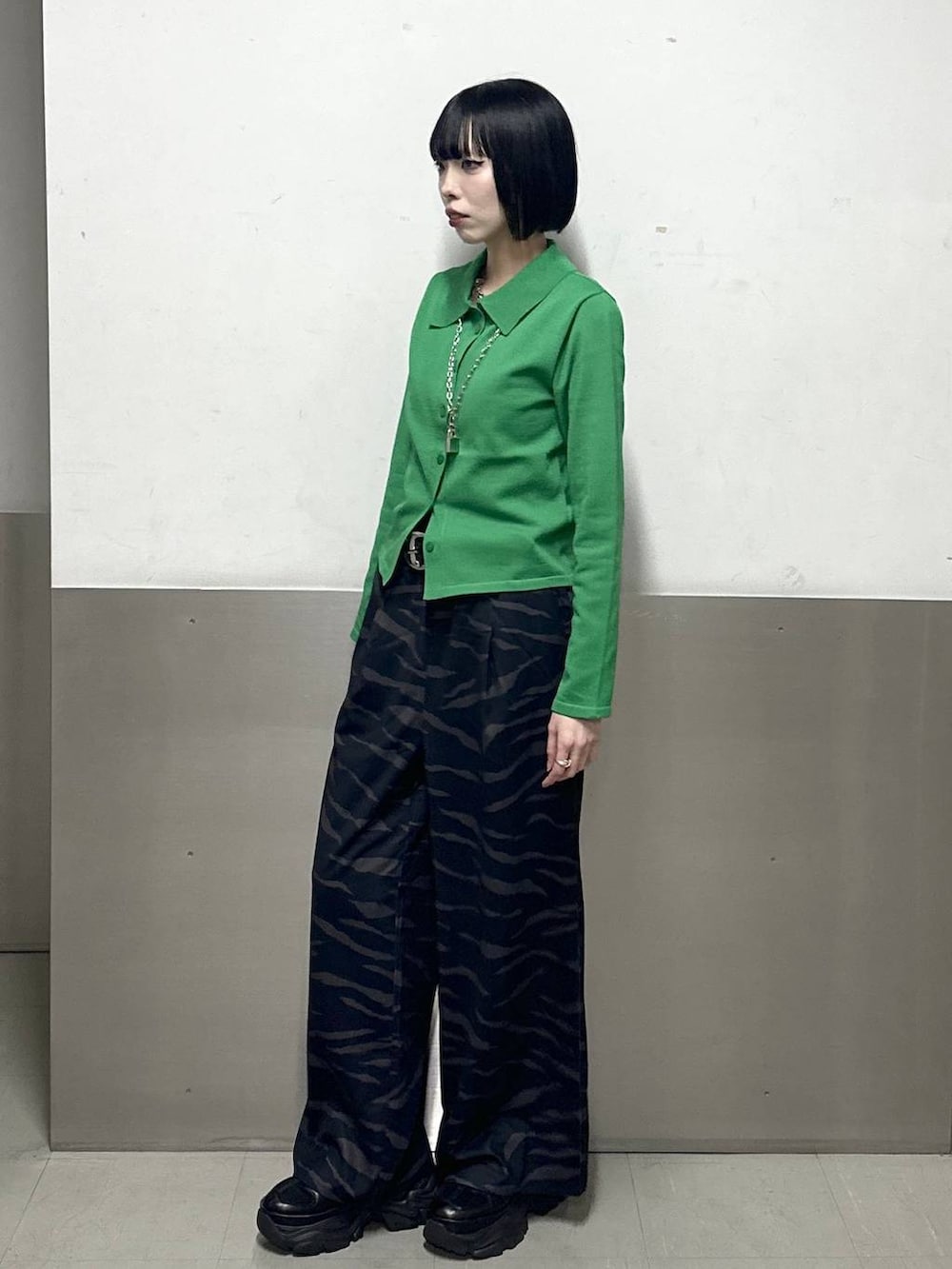 ブラック系のスニーカー、グリーン系のカーディガン/ボレロ、その他のスラックスを着用したレディースの冬コーディネートの3枚目の写真