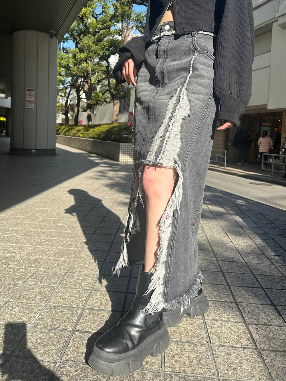 ホワイト系のニット/セーター、ブラック系のブーツ、ホワイト系のブーツを着用したレディースの春コーディネートの5枚目の写真