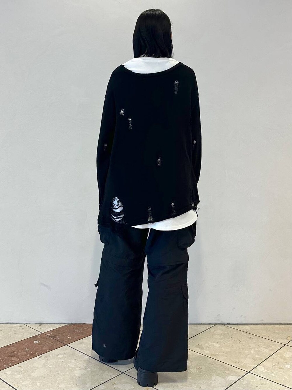 ブラック系のニット/セーター、ブラック系のカーゴパンツ、ブラック系のブーツを着用したレディースの冬コーディネートの4枚目の写真