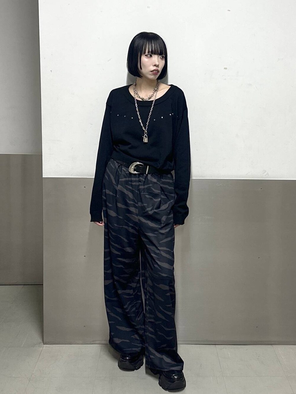 ブラック系のスニーカー、ブラック系のニット/セーター、その他のスラックスを着用したレディースの冬コーディネートの2枚目の写真