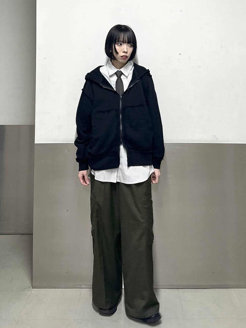 ブラック系のブーツ、グリーン系のスラックス、グレー系のシャツ/ブラウスを着用したレディースの冬コーディネートの2枚目の写真