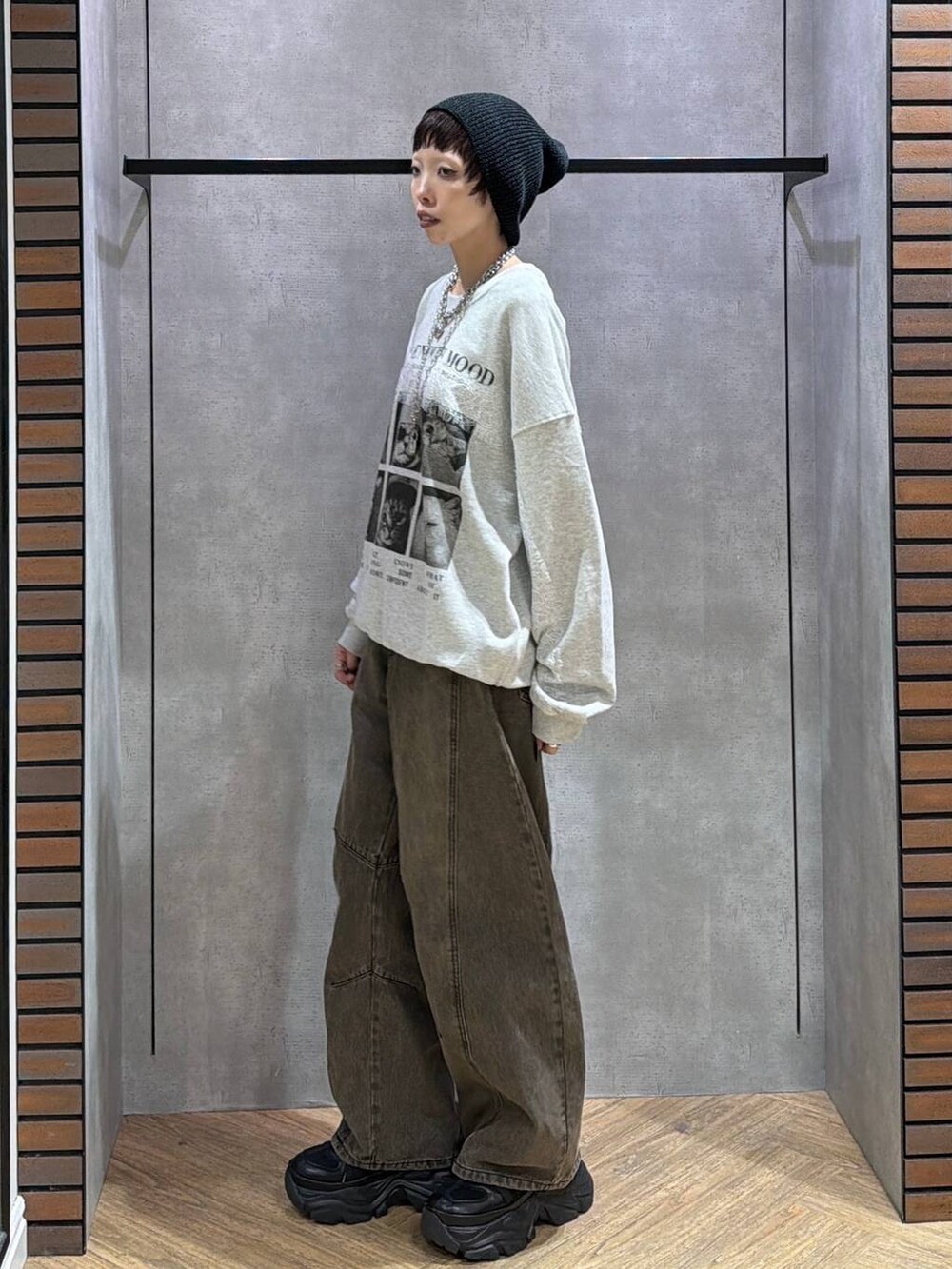 ブラウン系のデニムパンツ、ブラック系のスニーカー、グレー系のスウェットを着用したレディースの秋コーディネートの3枚目の写真