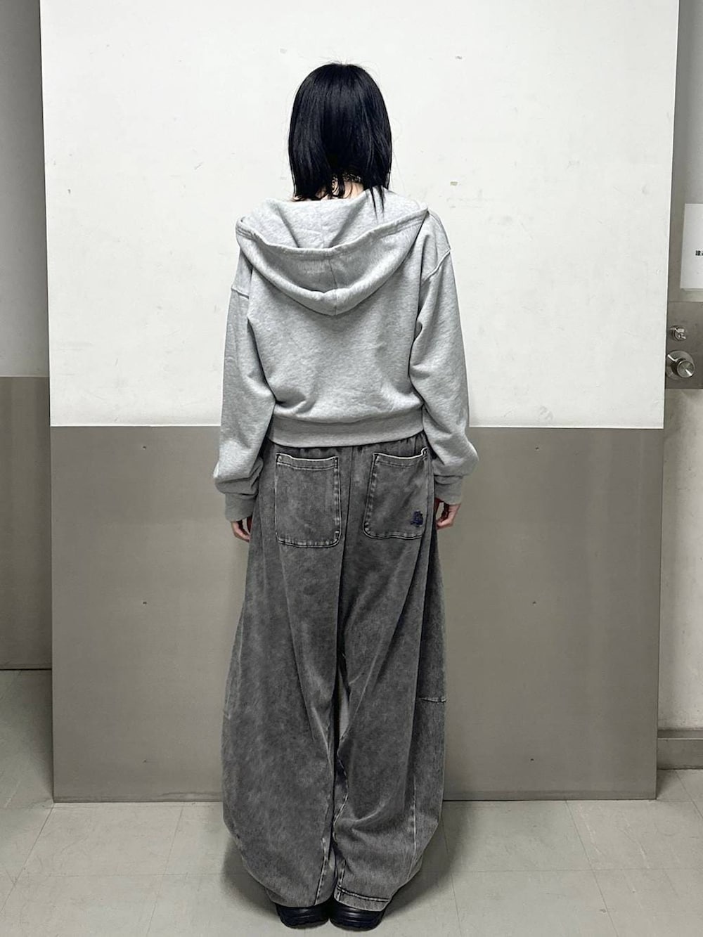 ブラック系のスニーカー、ホワイト系のニット/セーター、グレー系のパーカーを着用したレディースの冬コーディネートの4枚目の写真