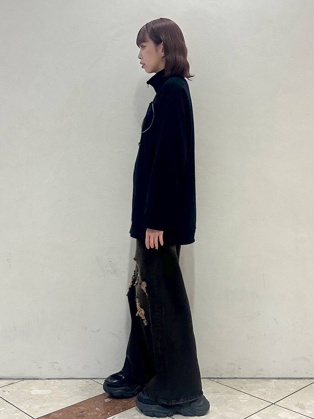 ブラック系のスニーカー、ブラック系のスウェット、ブラック系のデニムパンツを着用したレディースの冬コーディネートの3枚目の写真