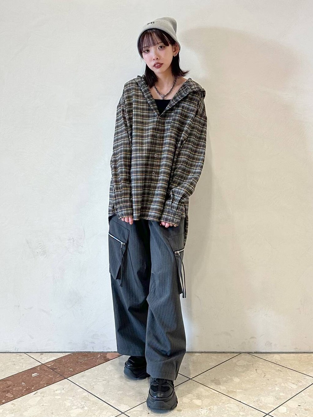 ブラック系のスニーカー、ブルー系のシャツ/ブラウス、ブラック系のネックレスを着用したレディースの冬コーディネートの2枚目の写真