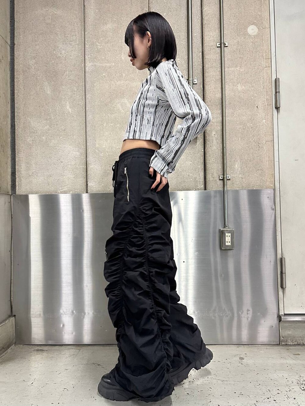 ブラック系のその他パンツ、ブラック系のブーツ、ブラック系のボストンバッグを着用したレディースの冬コーディネートの3枚目の写真