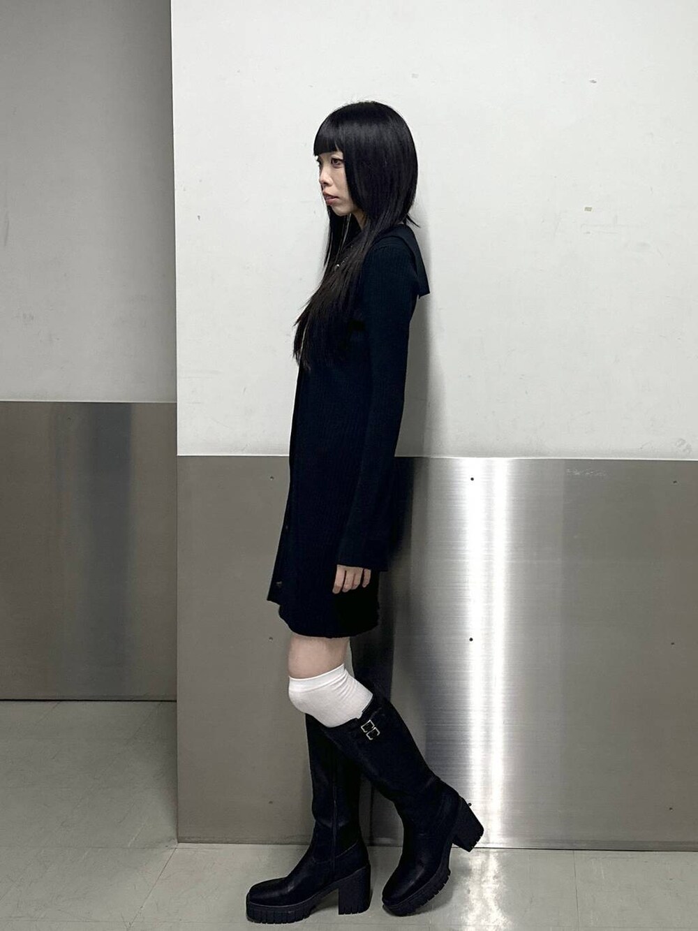 ブラック系のブーツ、ブラック系のワンピース、ブラック系のネックレスを着用したレディースの秋コーディネートの3枚目の写真